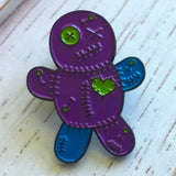 -Voodoo Doll soft enamel pin with rubber pin bac. Teal and purple on black metal base. Measures approximately 1inch. Shipped from the USA. Cute funny goth gothic horror witchcraft halloween pinback badge bag backpack hat lapel accessory pin-