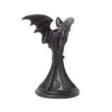 -Silent sentinel delighting in night. Flying on the border between one world and the next. Be it bird or beast at dusk or dawn, forever unseen at the dark of the moon. A beautifully sculpted Bat candle stick, hand finished in the finest quality black resin.&nbsp;A dark and dramatic candle stick to bestow your dining table, boudoir or altar. Genuine Alchemy product. This item typically ships in 1-2 business days from within the US.-