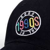 Born in the 1990s Cap, Black Embroidered Snapback Hat with Retro Logo-Embroidered Born in the 1990s cap with strap adjustment. One size fits most. This hat typically ships in 2-3 business days from abroad. Please allow an additional week or two for delivery. Retro, 90s, nineties, kid, birthday, 30s, 30th, gift for him or her or them-Black-