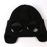 -Fashionable thick (160g) plush lined, knit polyester beanie with bomber cap style ear flaps and built in tinted goggles. Orange, black, white, green, purple, blue or yellow modern European style winter hat. A fun and functional fashion accessory for travel and outdoor activity on cold days. Free Shipping Worldwide. -