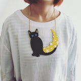 -Stunning, large acrylic necklace featuring a black cat with blue eyes set against a scattered star covered glittering gold crescent moon. Measures approximately 13cm/5.1 inches on a 40cm / 15.75in chain. Free shipping.

Cute kawaii harajuku trendy goth nugoth statement jewelry halloween witch witches spooky magical-