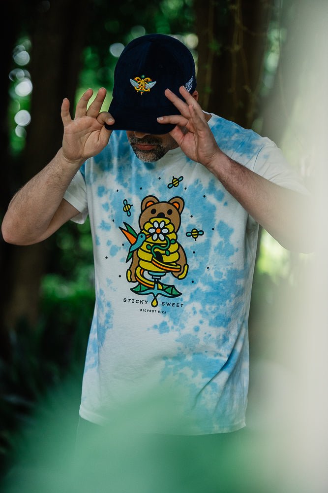 -"Cloud dyed" luxuriously soft cotton t-shirt with a Classic fit & relaxed feel. Cut, sewn & garment dyed in Los Angeles with limited edition artwork from Pseudodudo featuring a bear interrupting some bees & birds at the local honey jar, a playful design inspired by the important role pollinators play in our ecosystems.-
